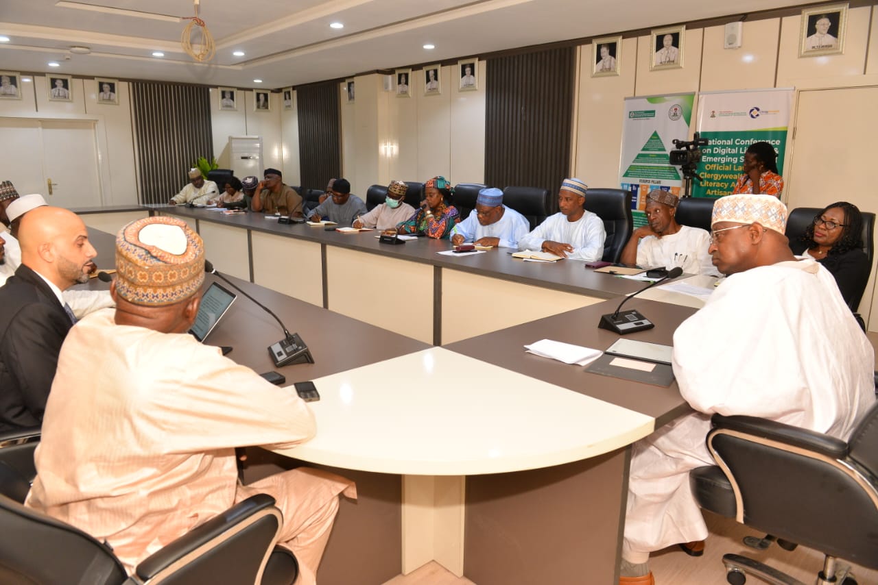 Livestock stakeholders seated around a board table with microphones and laptops.